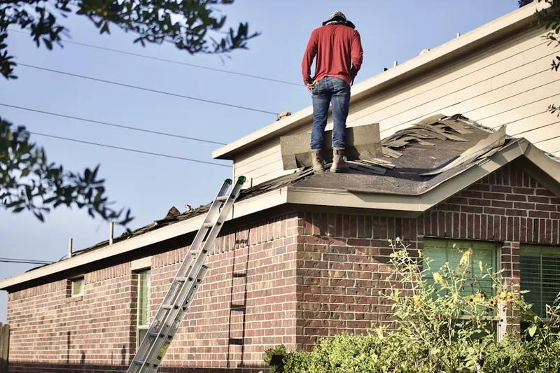 Professional roofer working on a residential roof in South Truro